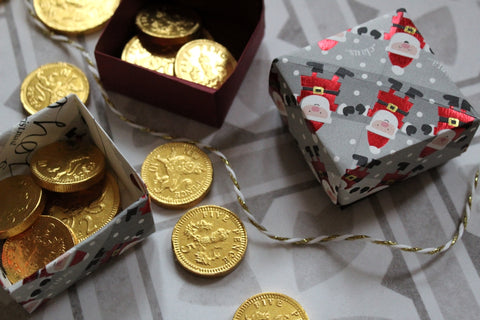 Photograph showing origami boxes made with Christmas wrapping paper and filled with chocolate coins