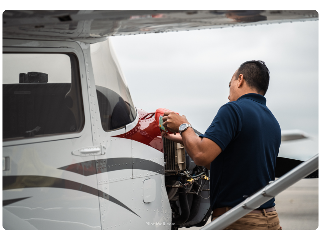 Un piloto poniendo un litro de aceite en el motor del avión - Pilot Mall