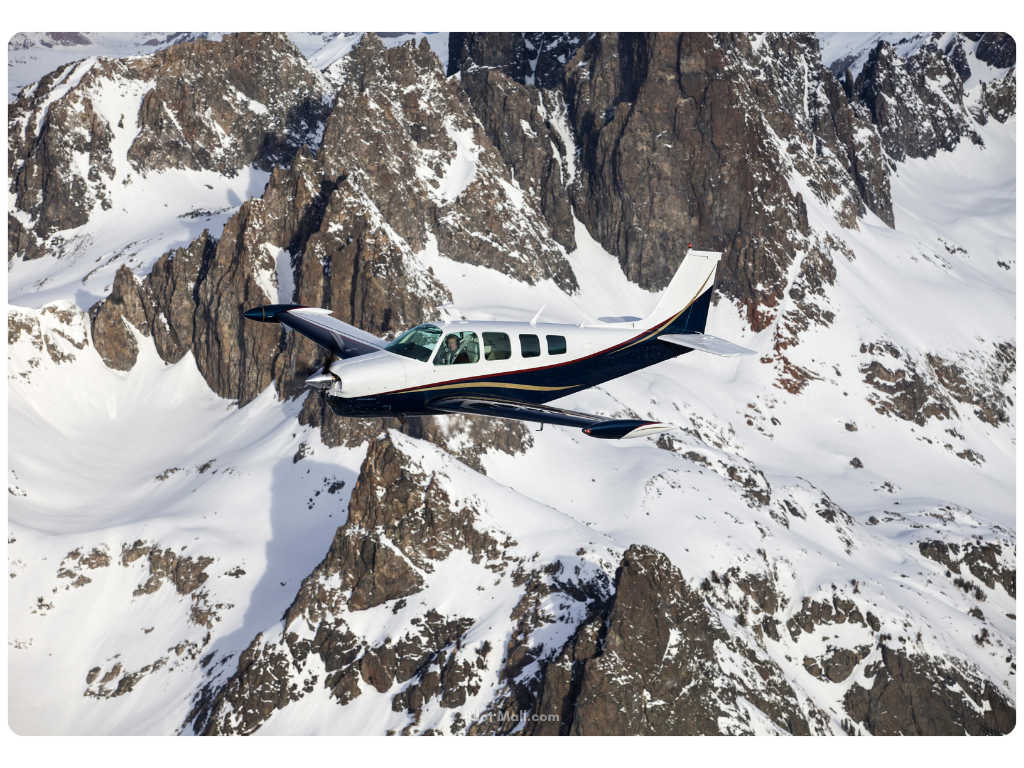 Beechcraft Bonanza en el cielo volando sobre las montañas- Pilot Mall