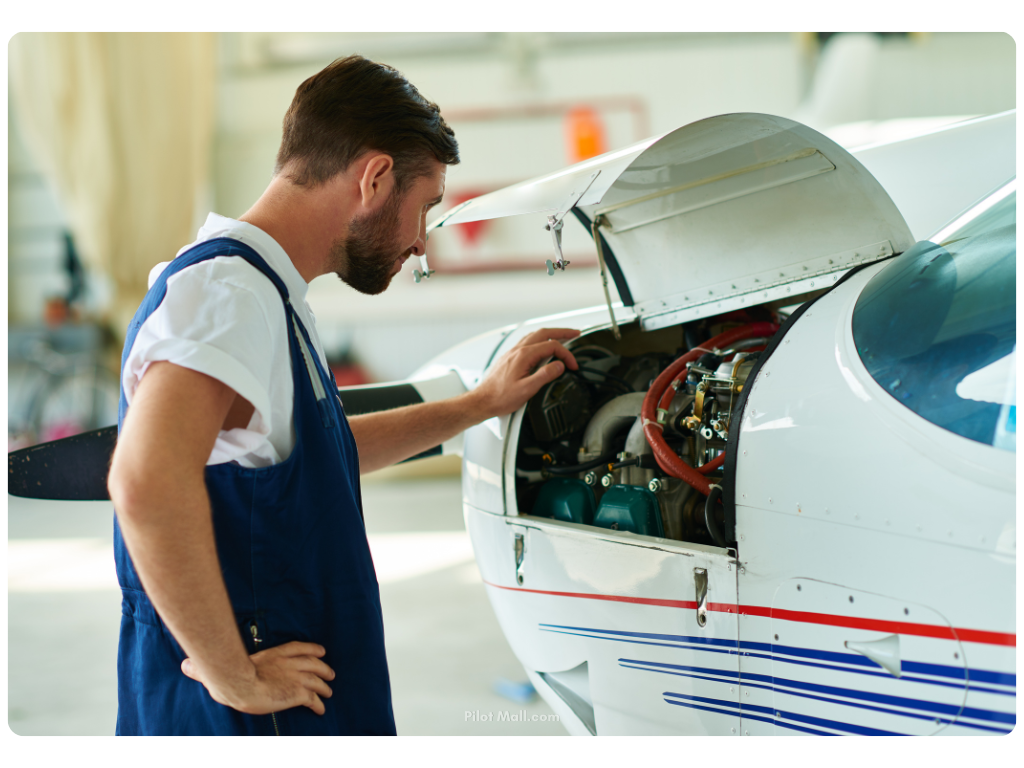 aircraft mechanic looking into the engine of a GA plane - Pilot Mall