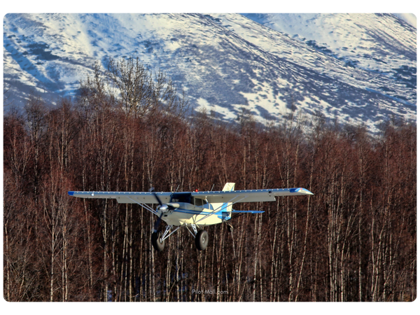 bush pilot flying a plane in a mountainous area