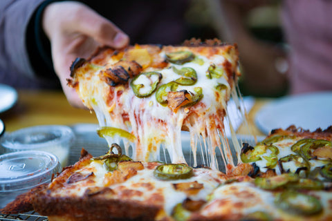 A slice of beautifully oozing cheesy pizza from San Francisco is picked up.