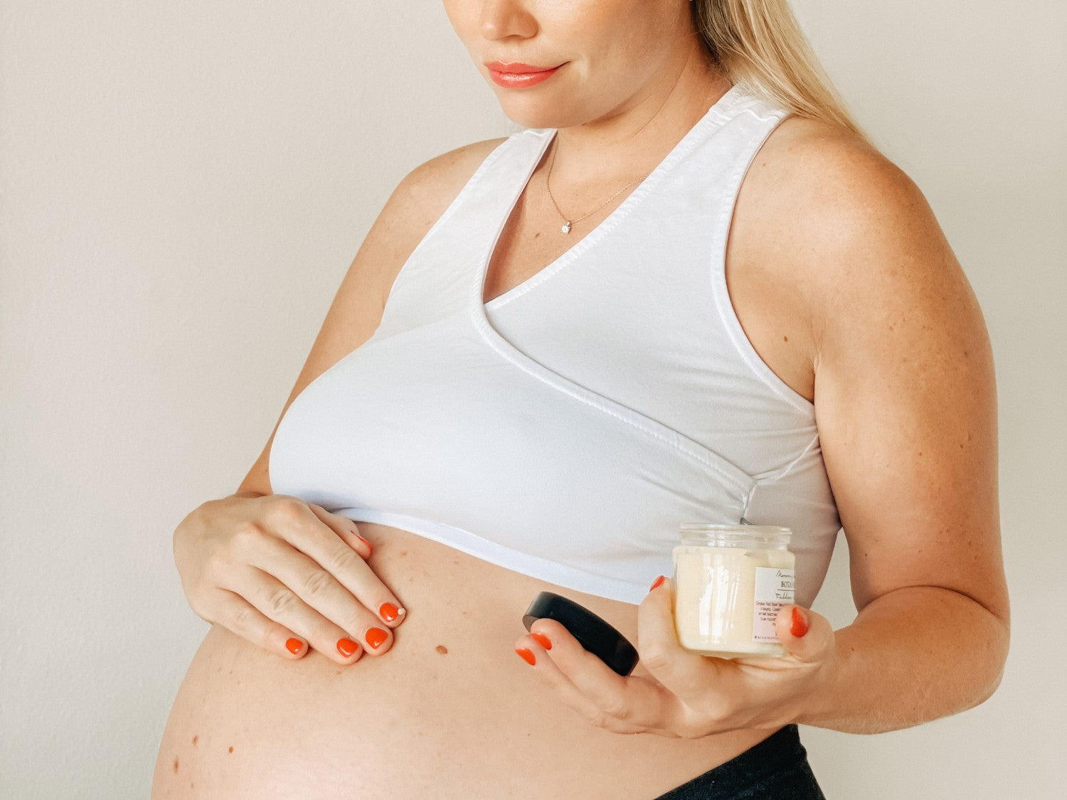 Pregnant mom moisturising her belly