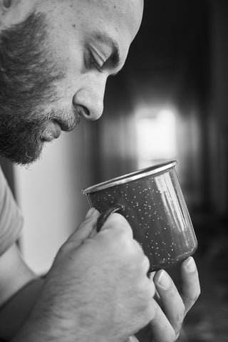 Man Examining Mug of Tea