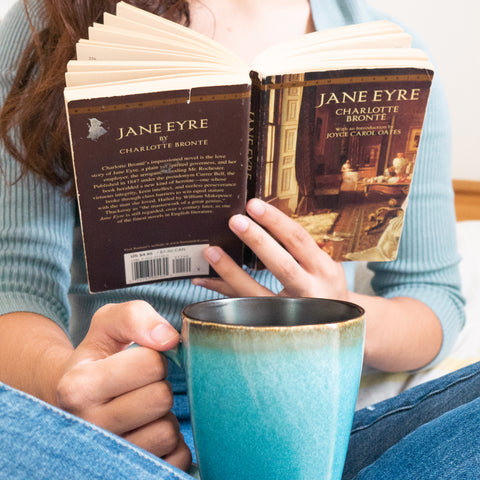 Woman reading with a mug of tea