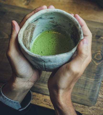 Green tea in a handheld mug