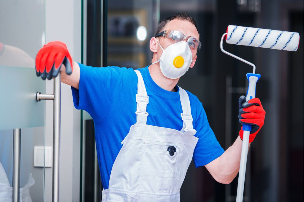 A painter wearing a mask to prevent health issues.