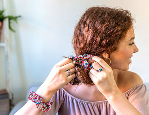 Women tying a Liberty scrunchie in her hair | Holme & Moss