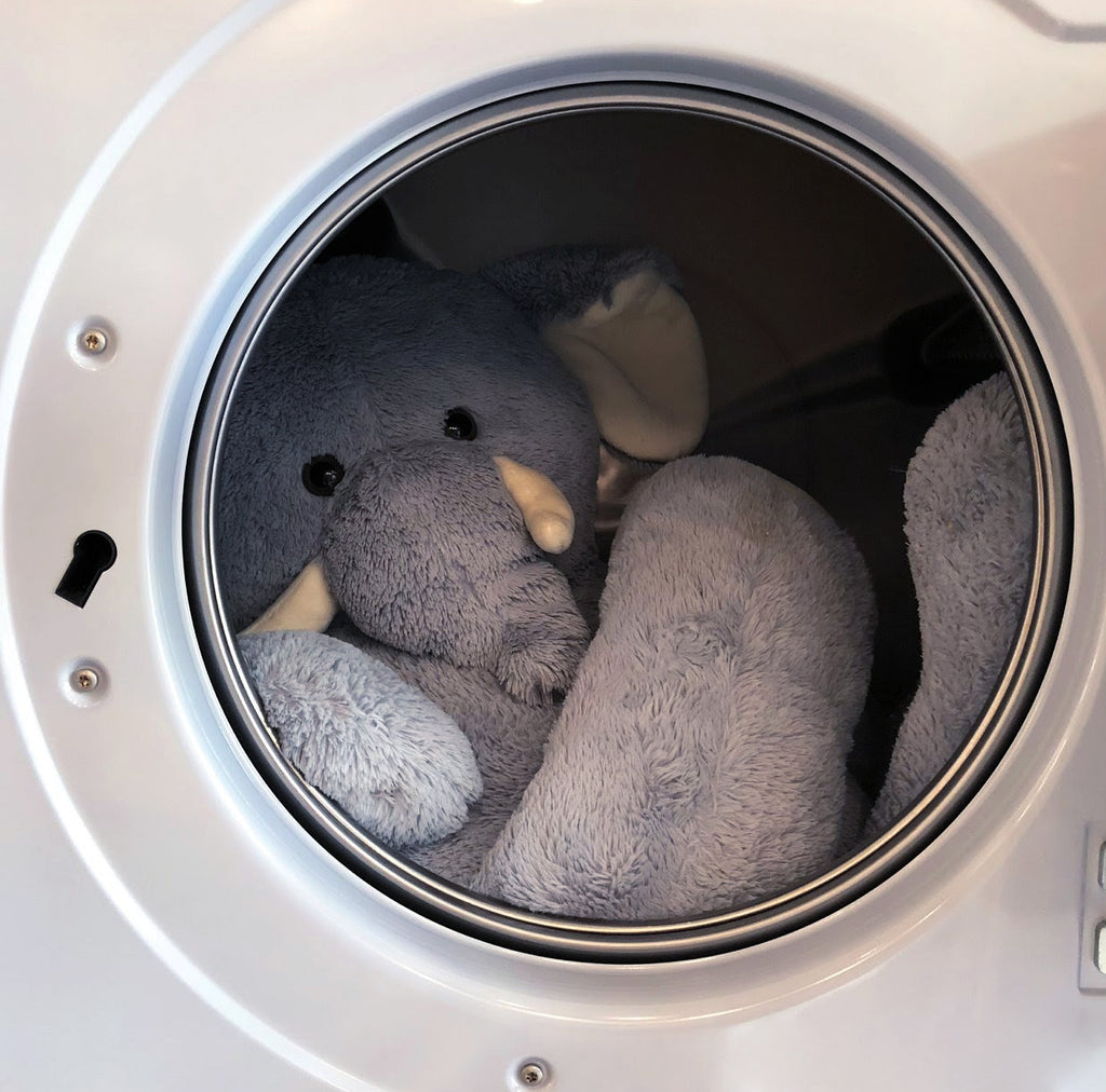 A large plush toy elephant in a washing machine