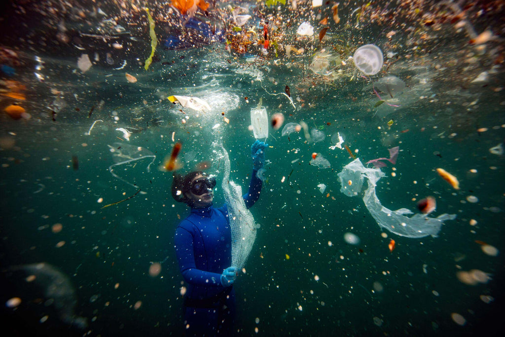 A diver surrounded by plastic marine debris