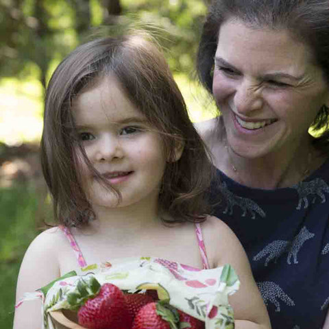 Michelle Zimora and her daughter, holding a bowl of strawberries covered partly with a Farmer's Market print Z Wrap