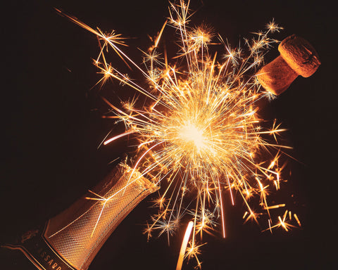 a champagne bottle popping open with a sparkler