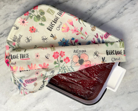 A white ceramic baking dish with beet brownies, wrapped in an XL Bees Love These print Z Wrap
