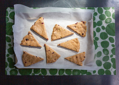 Cut, unbaked scones on parchment waiting for the oven; a Leafy Green XL Z Wrap covers the work surface under the tray