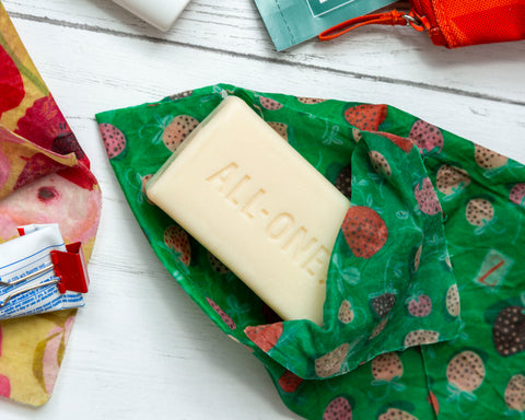 A Strawberry Fields print Z Wrap opens to reveal a bar of soap, surrounded my misc other bath items