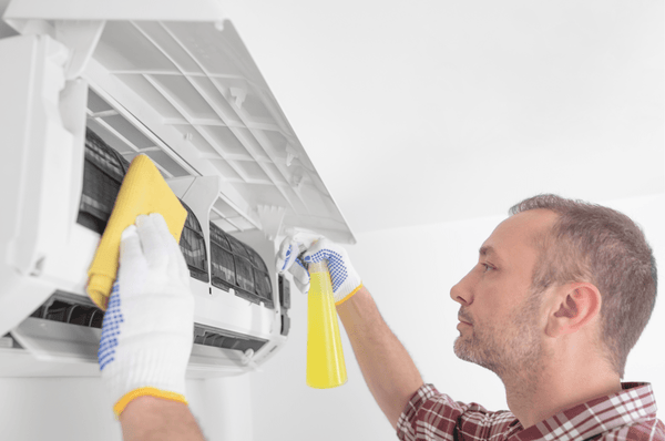 Person wearing gloves cleaning AC coils