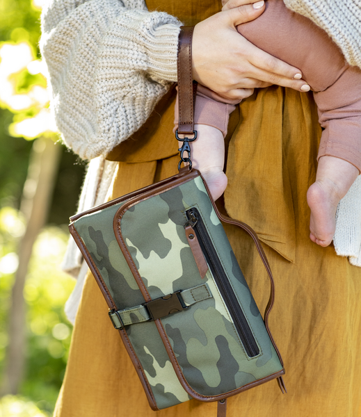 woman carries baby and dockatot changing bag