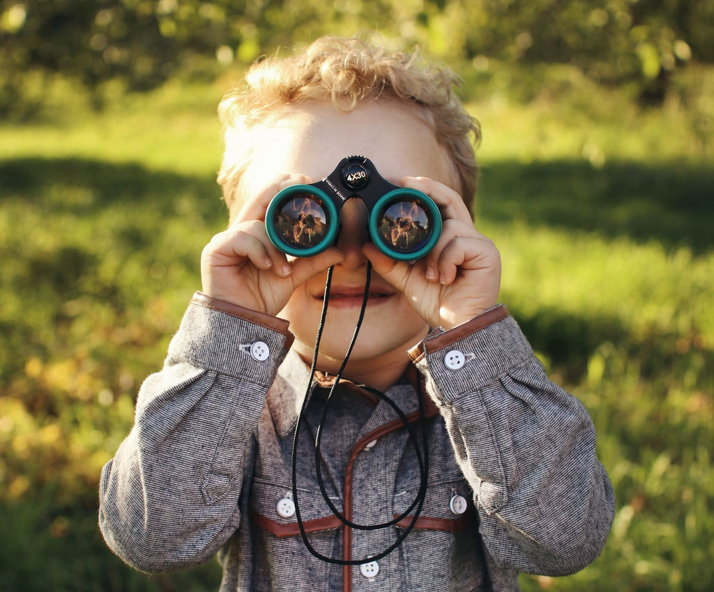 child with binoculars on garden playdate