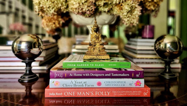 Mr. P's library books on top of antique table with large floral arrangement