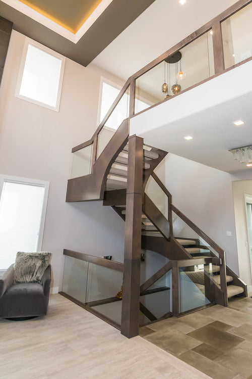 Light grey floor tile, grey side chairs, grey stairwell with clear glass railing.