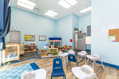 Light vinyl flooring, blue wall details, dark, and light maple furniture with green chairs.