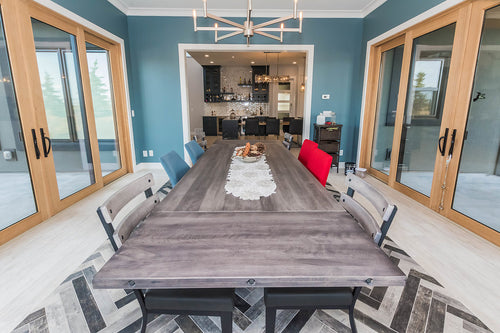 Wood patio doors, grey-ish blue wall colour, light grey floor tile with varying grey and black herringbone floor tile. Grey dining room table.