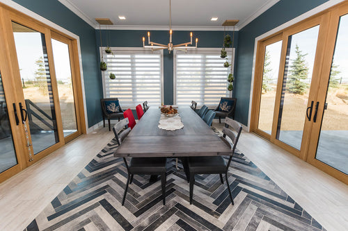 Wood patio doors, grey-ish blue wall colour, light grey floor tile with varying grey and black herringbone floor tile. Grey dining room table.