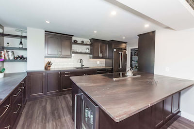 Brown vinyl floor with dark brown cabinets. Red, green, and beige granite with metallic champagne backsplash.