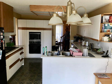 White melamine cabinet doors with recessed oak cabinet pulls. Green lino, yellow walls and a small sunshine ceiling.