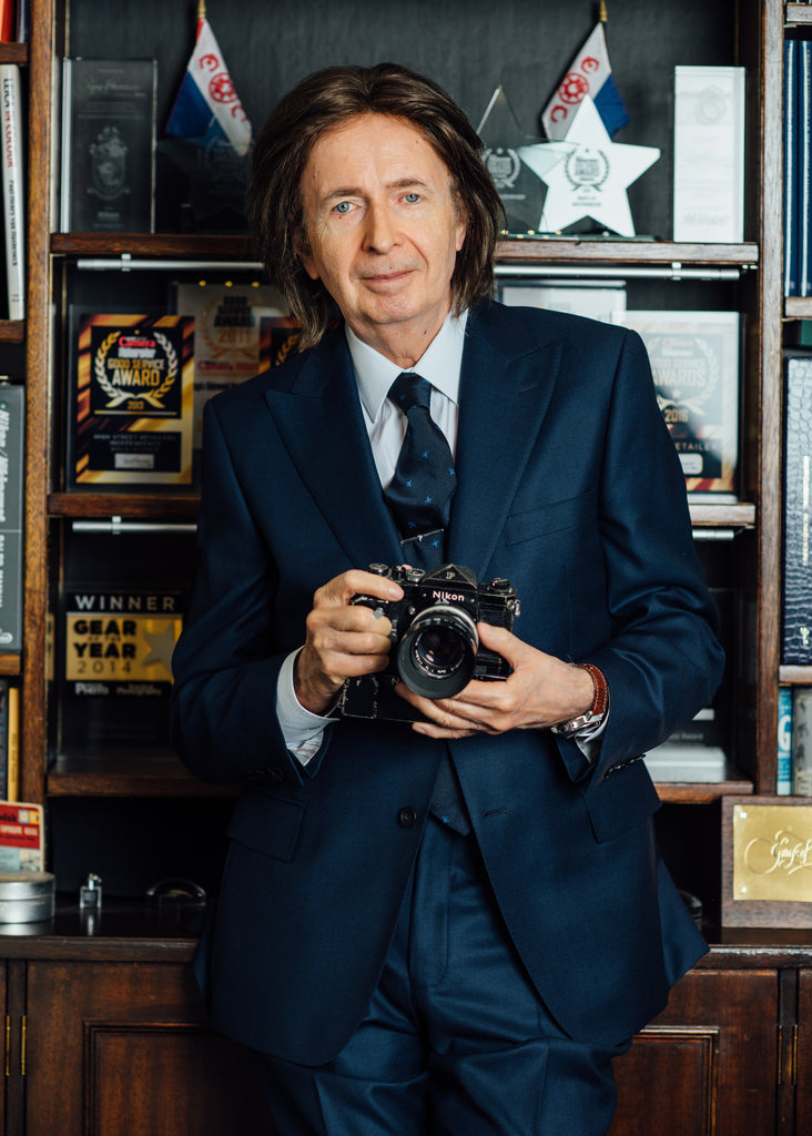 Gray Levett, founder of Grays of Westminster, with a Nikon F Camera.