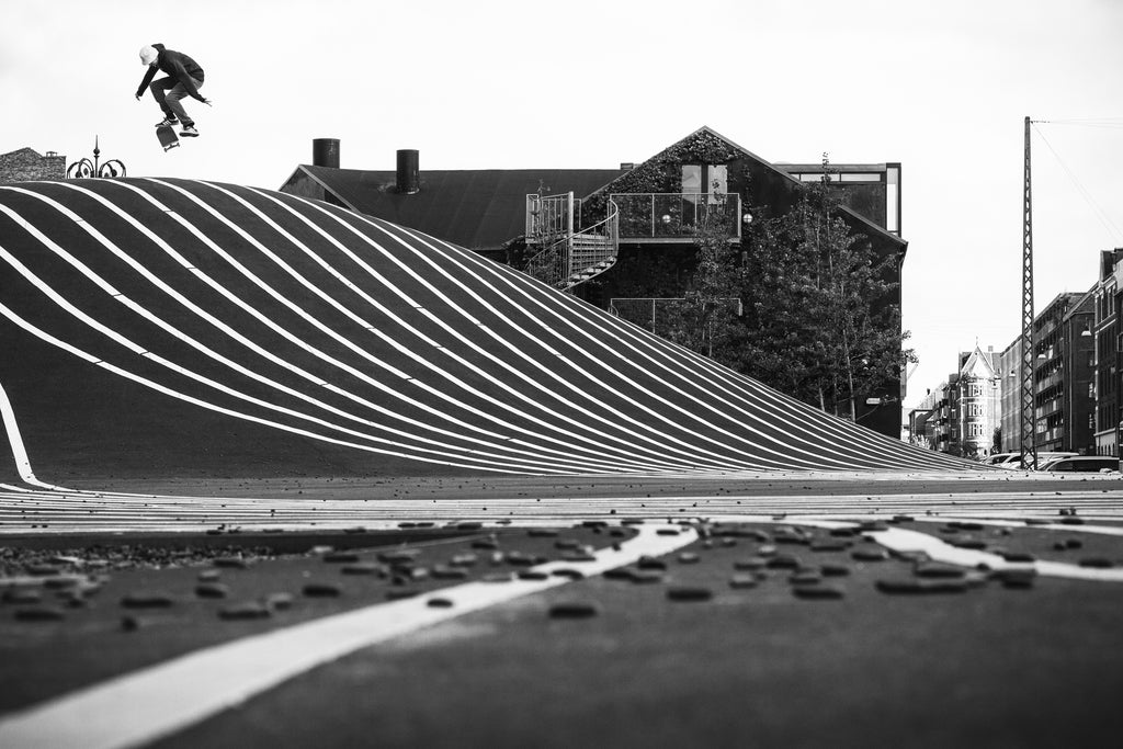 Nick Stansfield switch kickflip in Copenhagen, Denmark during an editorial project with Volcom clothing. Keeping things simple with a telephoto lens and high contrast black and white – Photo by Chris Johnson.