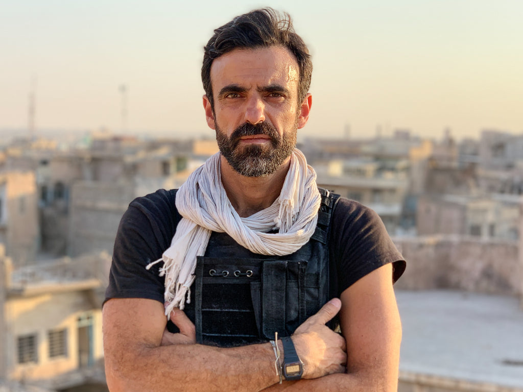 Paddy Dowling standing on the rooftop of a bombed school in Mosul. The risk here is unexploded bombs in the rubble and getting shot by snipers. Photo by David Bird.