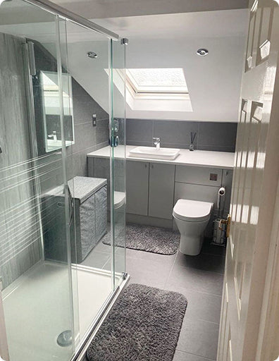 Image taken by an Unbeatable Bathrooms customer, showing their loft bathroom. Featuring a made-to-measure WC and Basin Unit, Walk-In Shower and LED Mirror Cabinet.