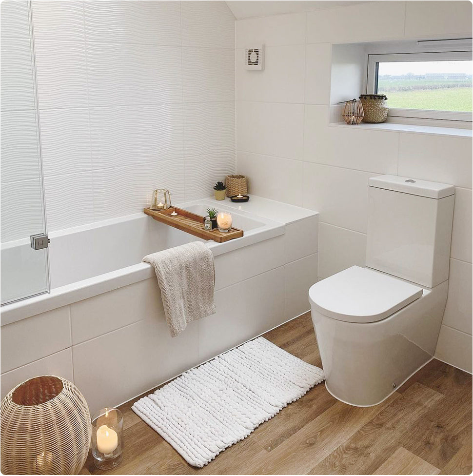 Image of a medium sized bathroom, with more space around each item. Featuring a shower bath, over the bath shower and toilet.