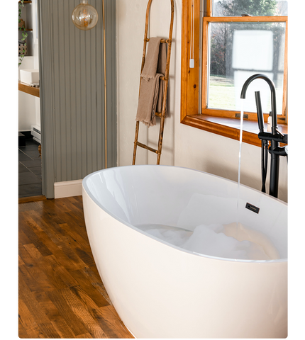 Large, curved, freestanding bath with matt black tap.