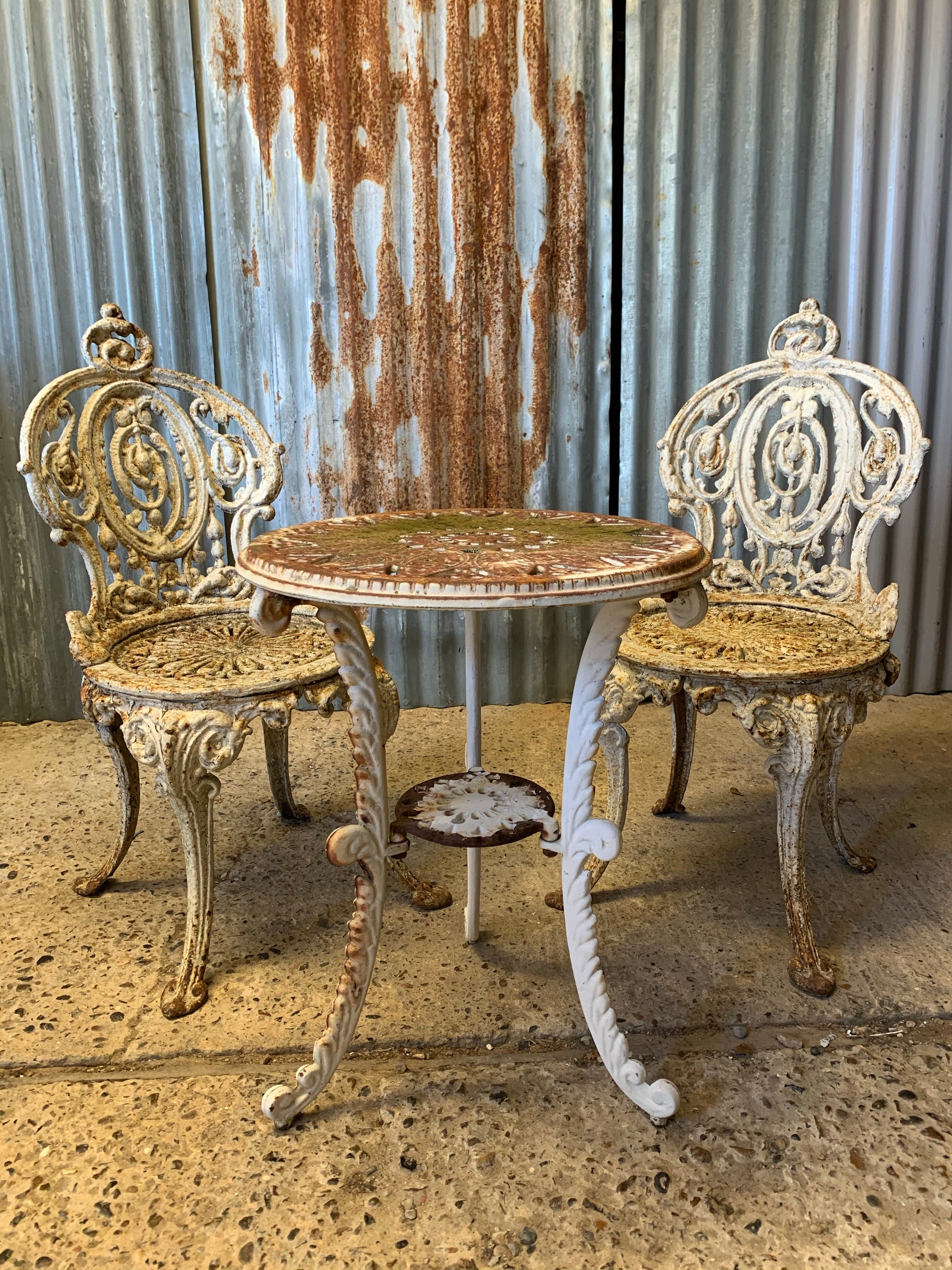 A pair of white cast iron Coalbrookedale chairs and complimentary bist