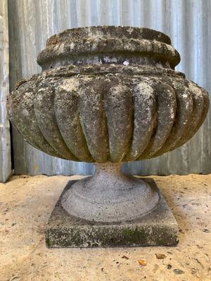A pair of large gadrooned cast stone urns