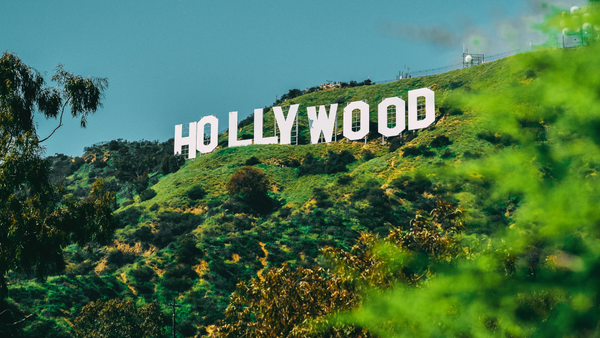 The Hollywood sign on a verdant hill with a deep blue, cloudless sky