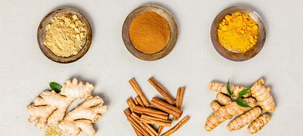 Three bowls filled with turmeric, ginger, and cinnamon
