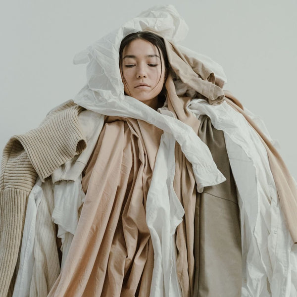 A woman covered in various shades of beige clothing.