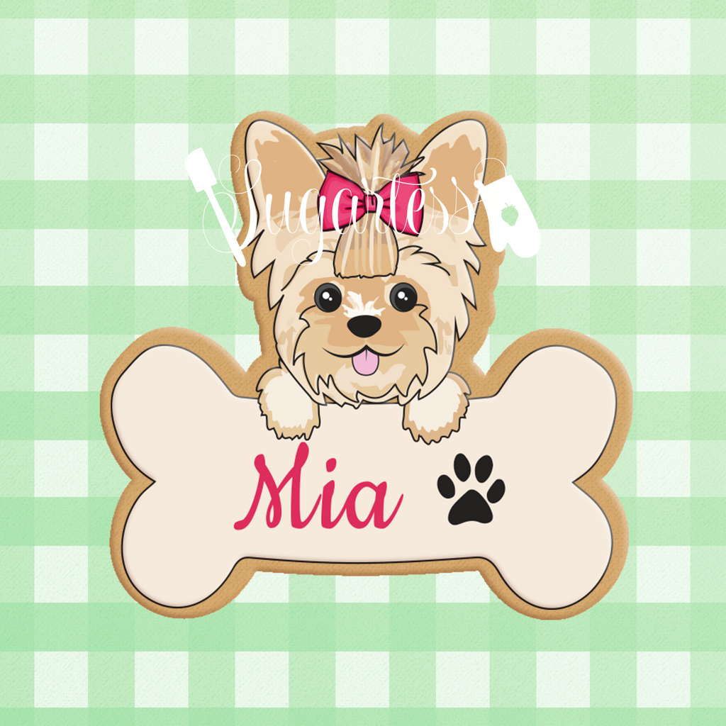 Sugartess custom cookie cutter in shape of a bone name plaque with girl Yorkie puppy dog head on top.