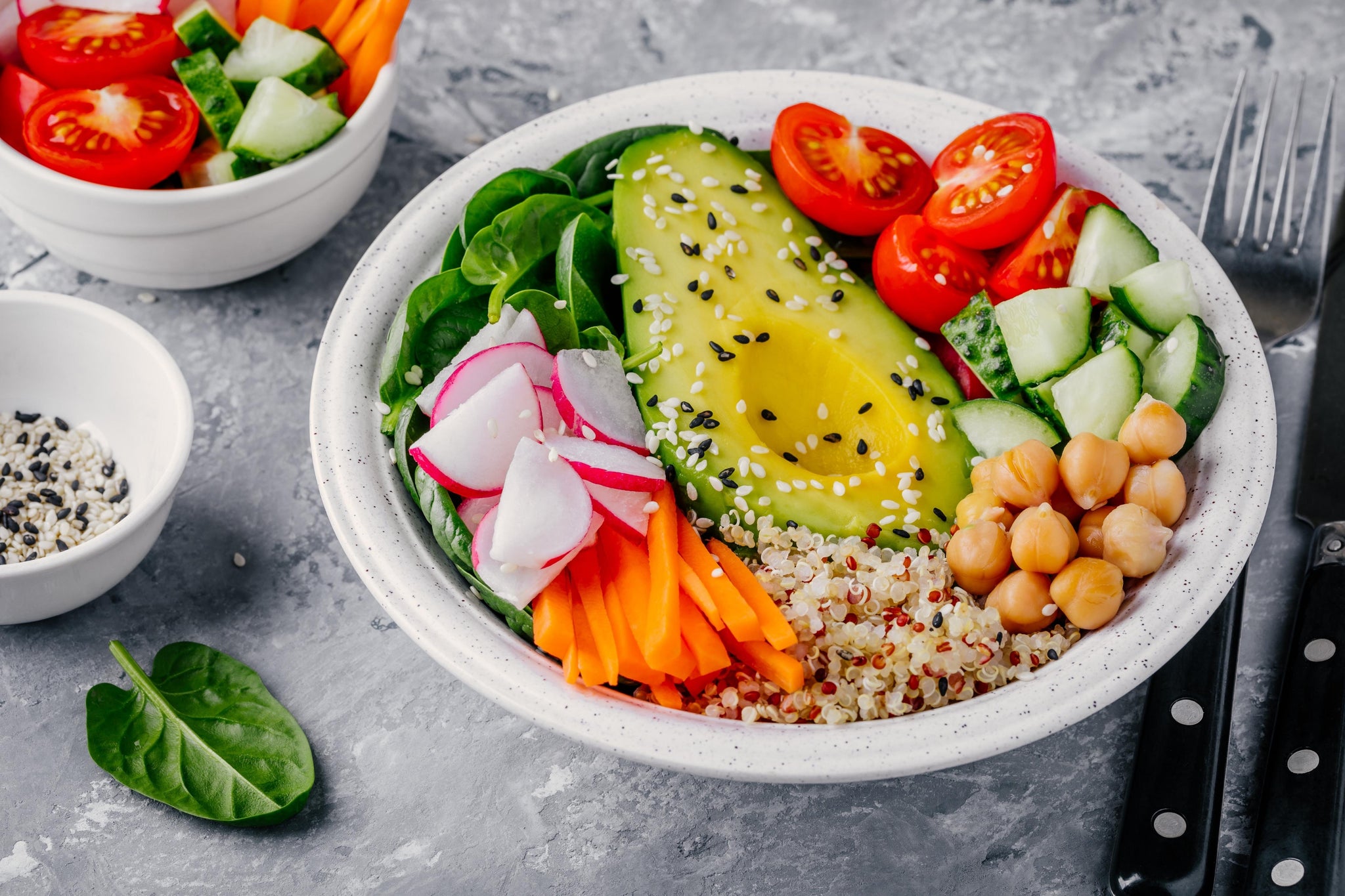 A bowl of avocado, chickpeas, cucumber, tomatoes, carrots, quinoa, and spinach: a diet recommended for high school football players