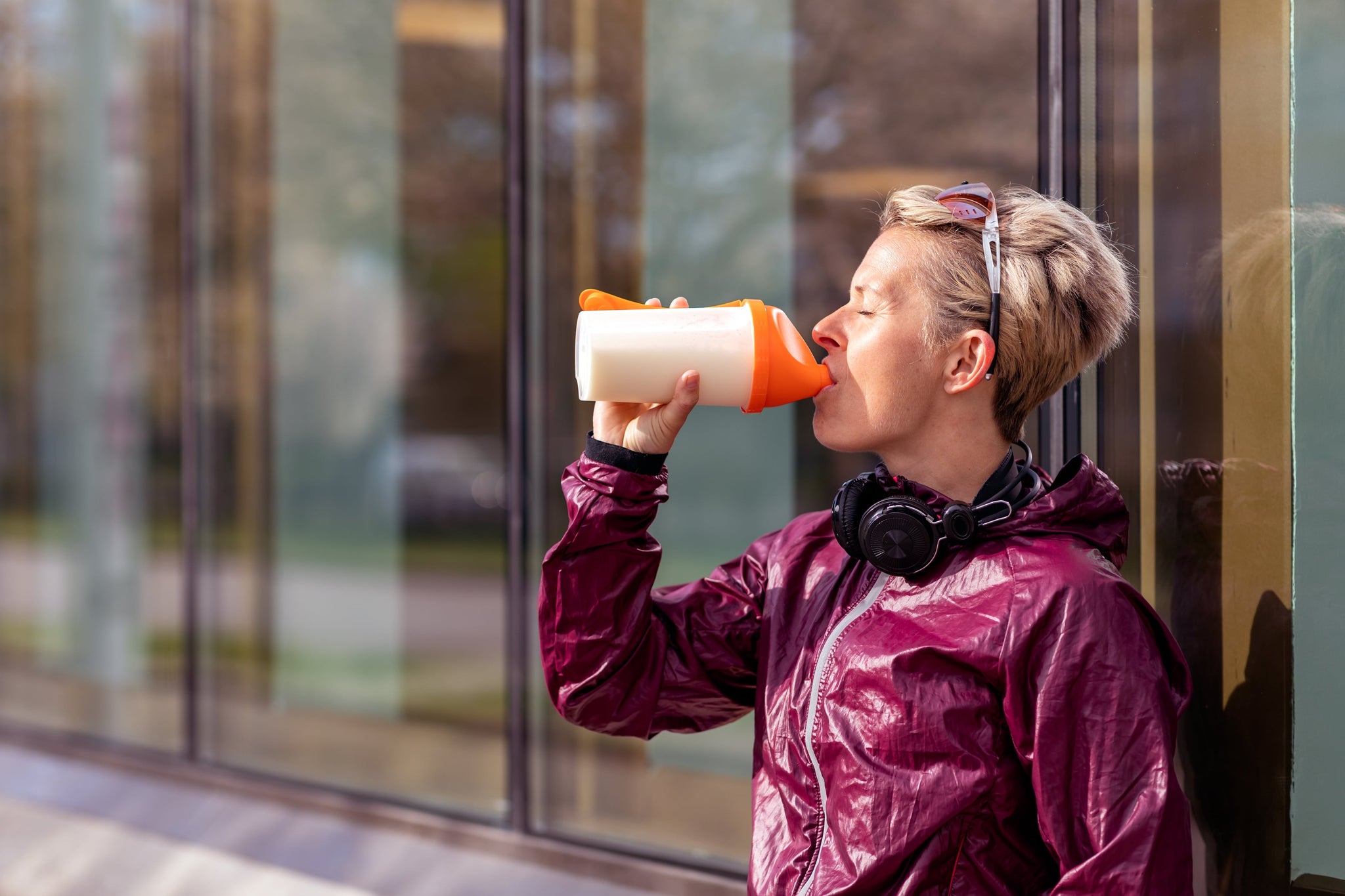 Woman in activewear drinking a dairy-free protein shake