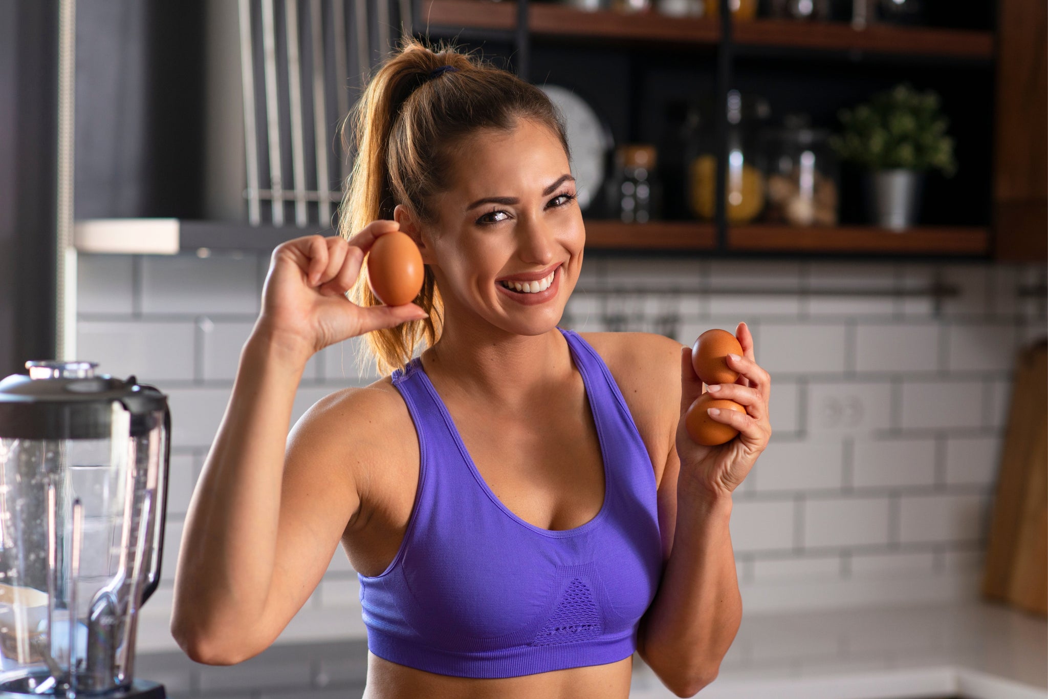 Fit woman holding eggs — one of the easy sources of protein