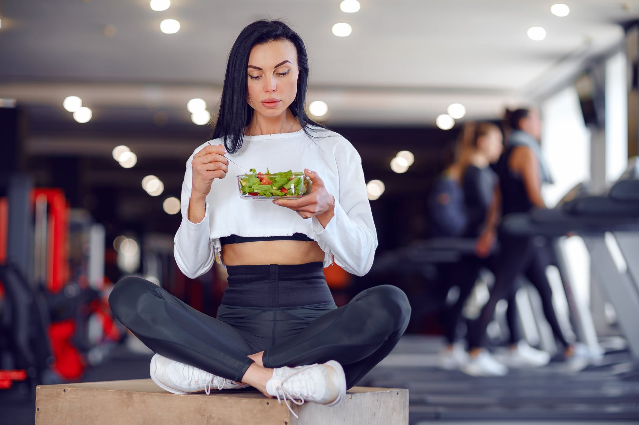 Female athlete eating protein-rich food in the gym