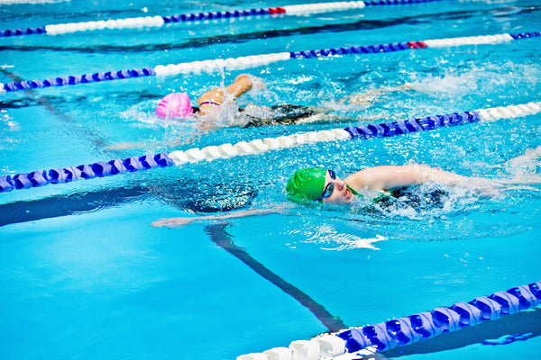 Female athletes swimming as part of their training to prevent knee pain when running