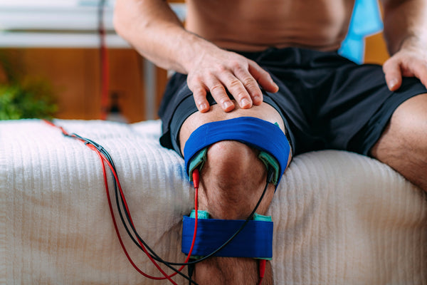 TENS machine on man's knee to prevent knee pain when running