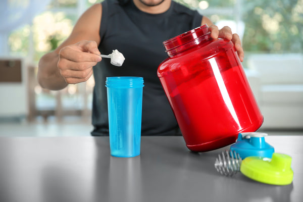 Athlete holding a scoop of whey protein