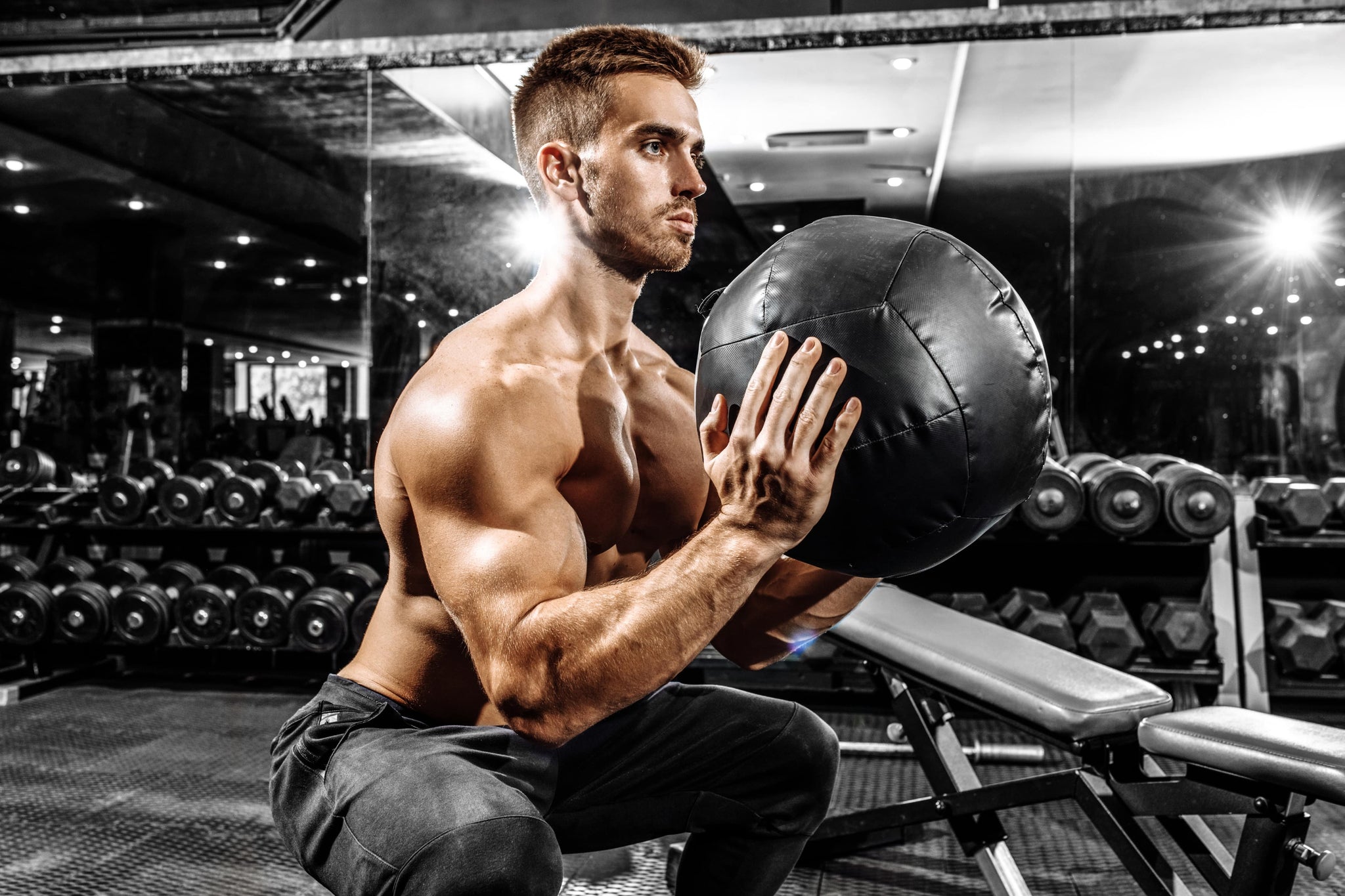 Sportsman performing medicine ball squat—one of the best exercises for how to prevent acl tears