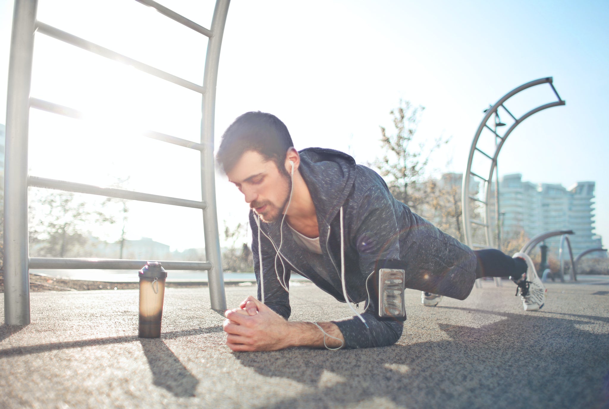 Man listening to a podcast discussing collagen benefits for men while working out at a park